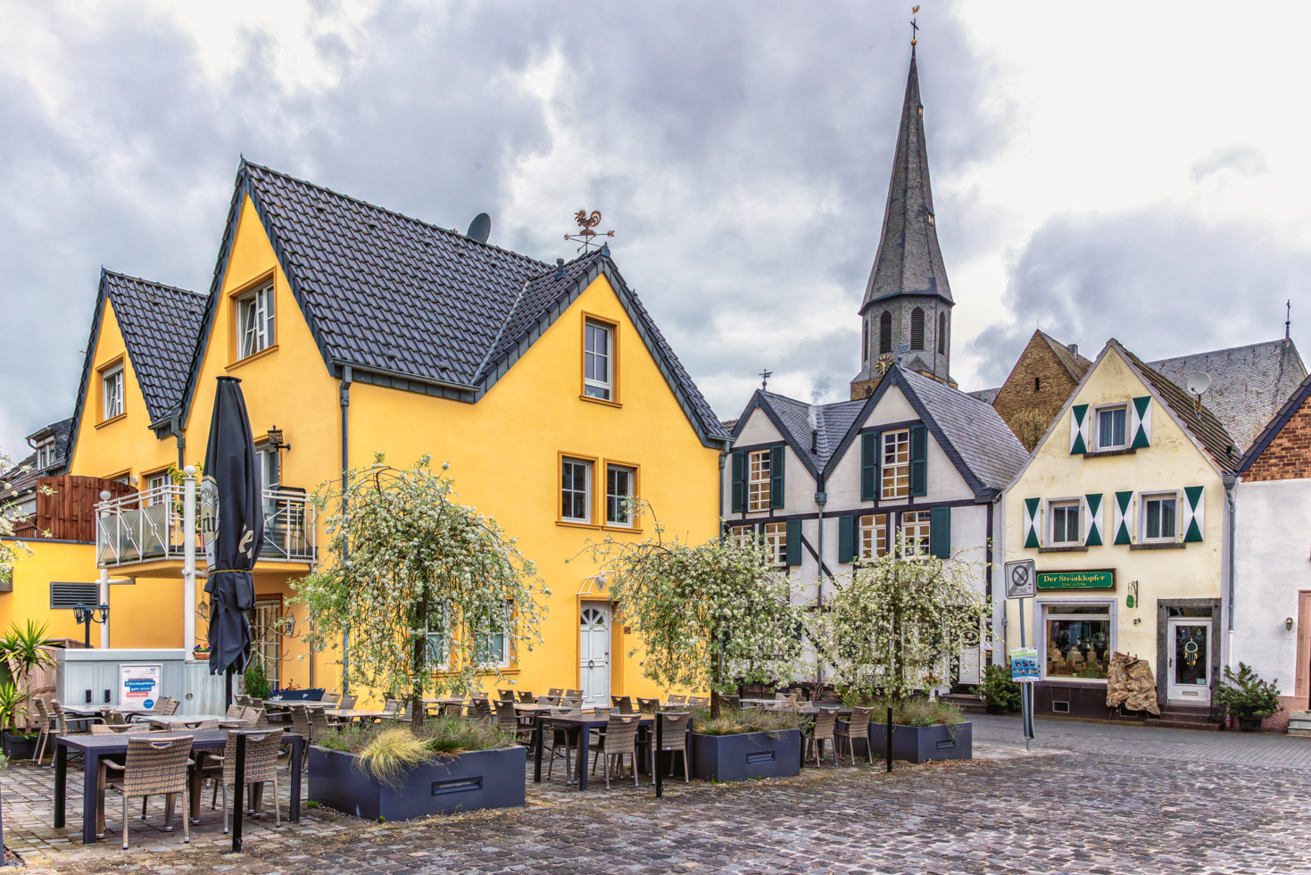 2026-04-FCa-039-Platz-am-Juddeturm-St-Martinus Platz am Juddeturm in der Altstadt von Zons. Im Hintergrund der Kirchturm von St. Martinus.