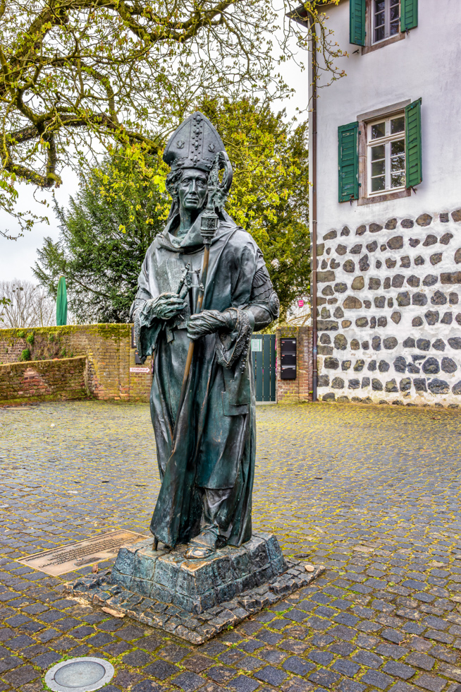 2026-04-FCa-049-Statue-Erzbischof-Friedrich-von-Saarweden-Zons Friedrich III von Saarweden (1370 - 1414 Erzbischof von Köln) Als Finanzfachmann verlegte er 1372 den Rheinzoll von Neuss in das näher am Rhein liegende Dorf Zons. Mit Urkunde vom 20. Dezember 1373 verlieh Friedrich von Saarwerden Zons die Stadtrechte und baute Zons zu einer stark befestigten Burganlage mit einem in der Anlage liegenden Schloss aus.