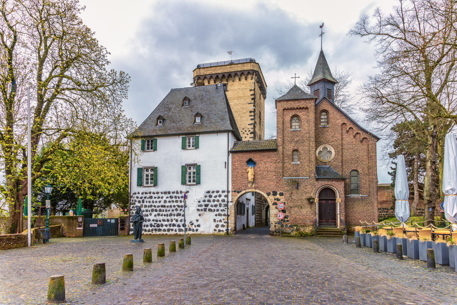 2026-04-FCa-051-Rheintor-Zons-Aussenansicht Das Rheintor Zons mit seinem mächtigen Rheinturm, in dem wie im Alten Zollhaus in vergangenen Zeiten der Zoll erhoben wurde. Das Zollrecht bestand im Mittelalter darin, von vorbeikommenden Reisenden und Händlern Zoll auf die per Schiff beförderten Waren zu erheben.