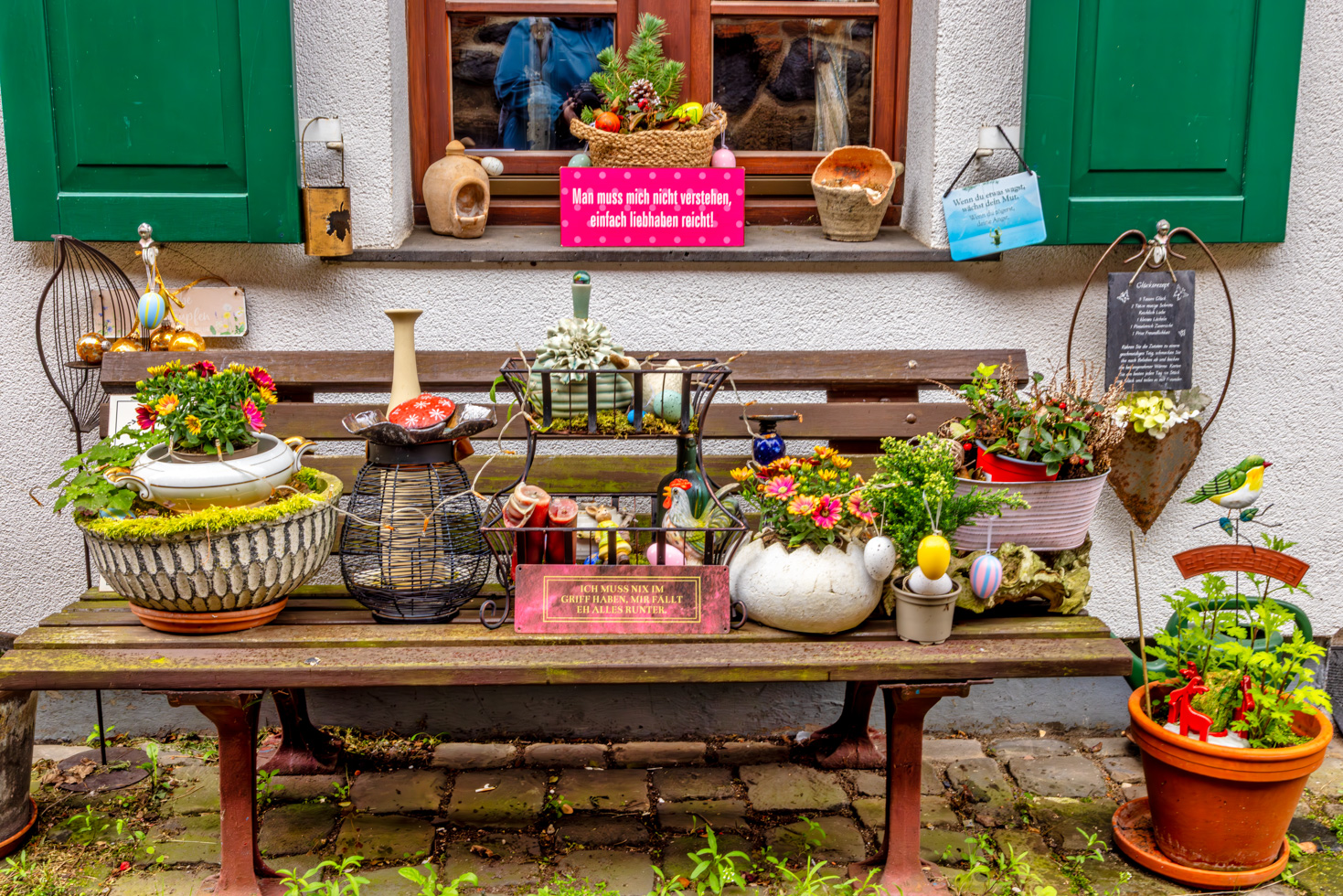 2026-04-FCa-053-Spruechehaus-Zons Ein buntes Allerlei vor einem Haus in Zons